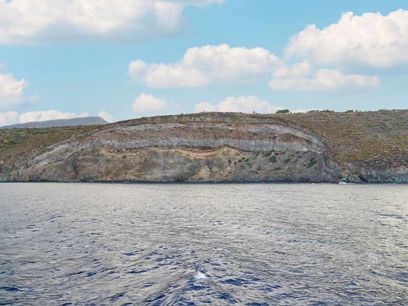 Figura 1: In foto è presente la stratificazione di Cala Nikà. Nella parte sommitale della stratificazione di 'Cala di Nikà' è presente il Tufo Verde (principalmente di colore verde, ma in alcune zone presenta un colore grigio scuro/nero)