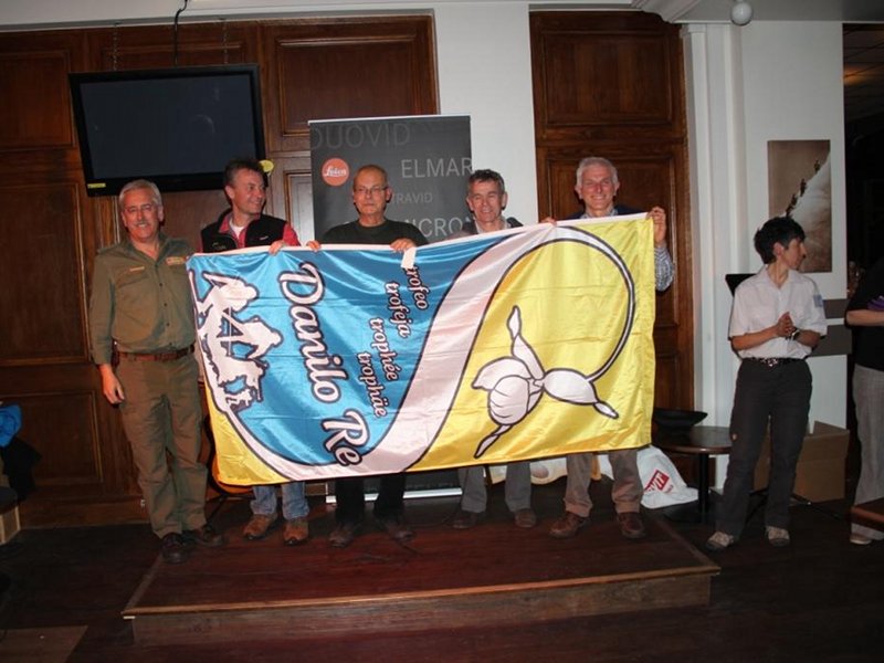 Il comitato organizzatore consegna al direttore del Parco Naturale Adamello Brenta (Roberto Zoanetti sulla destra) la bandiera come testimone per l'organizzazione dell'edizione 2014